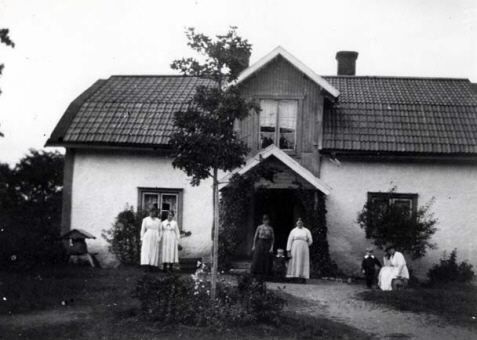 Familj som står framför ett hus