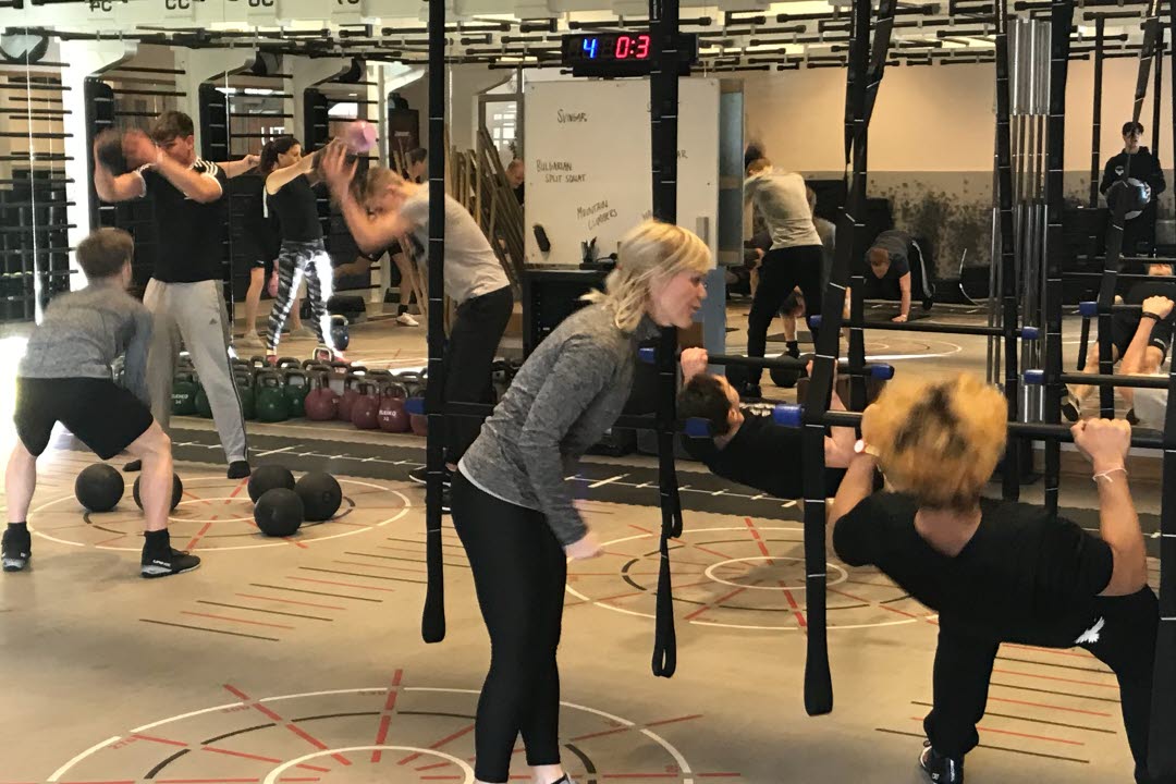Vuxna kvinnor och män som tränar på ett gym