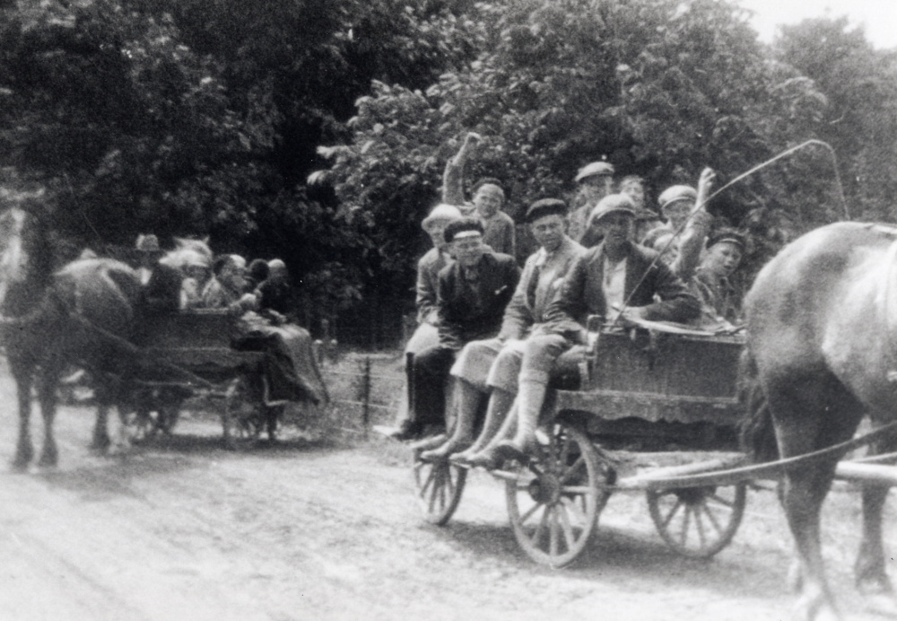 Skolbarn från Hjälmsta skola åker remmalag på Visingsö 28 juni 1933.  Läraren Josef Andersson sitter i mitten på den första vagnen, iklädd golfbyxor och basker.  Josef Andersson arrangerade minst varannat år skolresor runt om i Sverige.