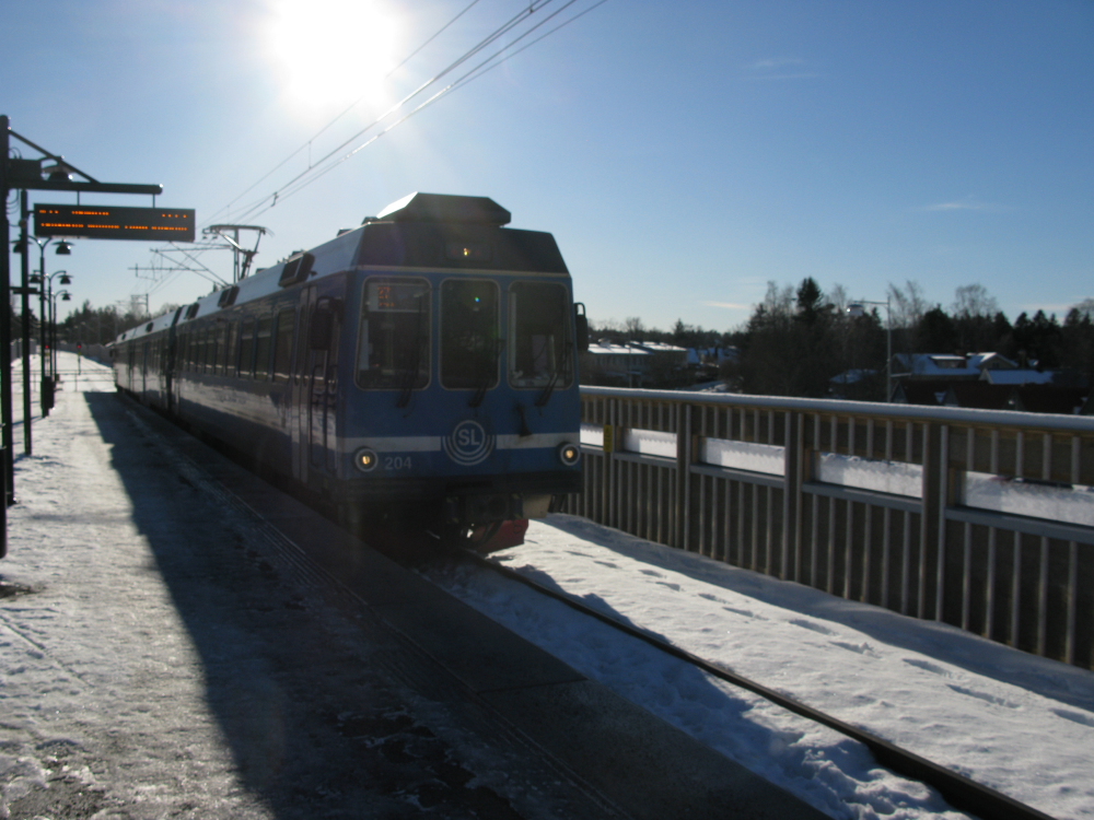 Ny station med mittplattform i Bällsta. Ett tåg har stannat till vid perrongen. Dubbelspår byggdes här 2014. 