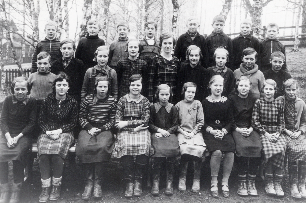 Lärarinnan Signe Andersson tillsammans med skolbarnen i Åvasta skola vårterminen 1936. Övre raden fr v Sven Andersson, Martin Grandin, Sivert Gustafsson, Stig ?, Rune Jansson, Valle Johansson, Rune Nyberg och Åke Andersson. Mellanraden fr v Berthold Östervall, Lars Ekberg, Aina Lund, Stina-Lisa Karlsson, lärarinnan Signe Andersson, Maj-Britt Lindblom, Stina Andersson, Henry Larsson och ? Gustavsson. Nedersta raden fr v Britta Andersson, Gertrud Rann, Sanna Jansson, Elvy Jansson, Rut Jansson, Inga Andersson, Ingegerd Eliasson, Doris Johansson och Gullan Wadström
