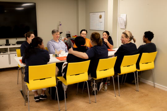 Anna-Lena håller i språkutbildning med deltagare som sitter runt ett bord