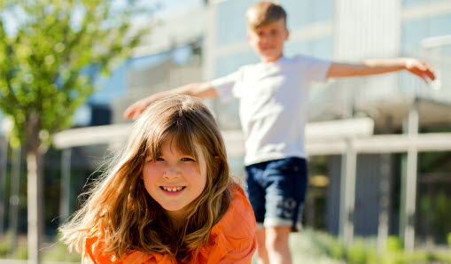 Elever leker ute på skolgården en varm sommardag