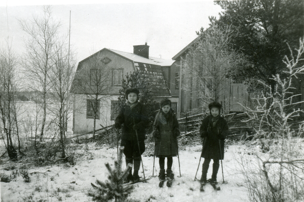 Nordhem Ösby 22, byggt på 1930-talet. Hem för Hulda och Helge Bergqvist. Parets barn Henry född 1924, Ulla 1926 och Bertil 1927 fotograferas på skidor i snön utanför huset. 

Familjen bodde på den övre våningen i huset till vänster. Nedervåningen var cykelverkstad och smedja. I huset bakom (till höger i bild) fanns två bostadsrum, en plåtverkstad och ett förråd. Här bodde Helges bror Helmer Bergqvist och en anställd smed som hette Oskar.