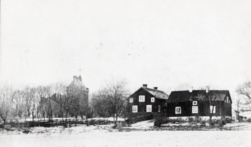 Vallentuna kyrka sedd från öster. Huset i mitten är Vallentuna prästgård. Huset t v är Arrendatorsbostaden