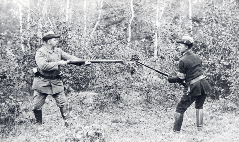 Medlemmar i  Landstormen  i Kårsta t v  Erik Edlind  Eriksdal och  Bernhard Ahlgren  Ekskogen i 'närkamp' med  gevär  Båda har  landstormshattar  och armbindel med krona på och Ahlgren har märke på hattens brätte (förmodligen Edlind också men hans "märkessida"är vänd från kameran)