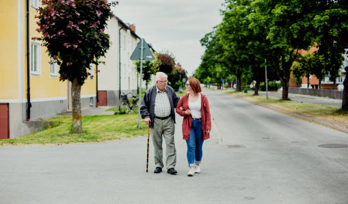 Äldre man och ung kvinna går på en väg