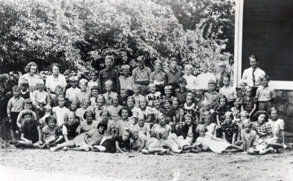 Kårsta kyrkskola.  Skolfotografi med läraren Halvar Hedler.  I övre raden står fr v lärarinnorna Margit Hultman och Jenny Johansson, Karl-Olov Hedler, Karl-Olov Åhman, Torsten Viman, Lennart  Åhman, Sverre Larsson, Karl-Erik Åkerberg, Bengt Svärd, Knut Karlsson, Hans Magnusson, Börje Karlsson och läraren Halvar Hedler.  Andra raden fr v okänd, Arne Andersson, okänd, Lasse Lindblad, Sören ?, Stig Viberg, okänd, Benny Chubb, Hans Sandgren, Olle Karlsson, Bengt Karlsson, Rolf Pettersson, Karl-Erik Engström, Rune Karlsson och Lasse Andersson.  Rad 3 fr v August Salby?,  okänd, okänd, Gunni Karlsson, Eivor Lundin, Ulla Bondesson, Elsa Eklund, Maj-Britt Jansson, Solveig Johansson, Gertrud Karlsson, Marianne Stjernberg, Gunnel Hedler, Elsy Söder, Birgitta Hedler, Birgit Bondesson, Rut Åkerberg, Svea Söderström, Naima Söderström och Nils Söder.  Rad 4 fr v Marianne Engström, Kerstin Sandgren, Dagmar Sandborg, Kerstin Berglund, Solveig Bergström, Elly Andersson, Kätie Chubb, Doris Söder, Inga Asplund, Gerd Eriksson, Eva Karlsson, okänd, Stina Eklund och Gun Bergström.  Liggande fr v Britta Berglund, Elsa Karlsson, Gunvor Eriksson, okänd, Ulla Stark och Elsa Sommarin