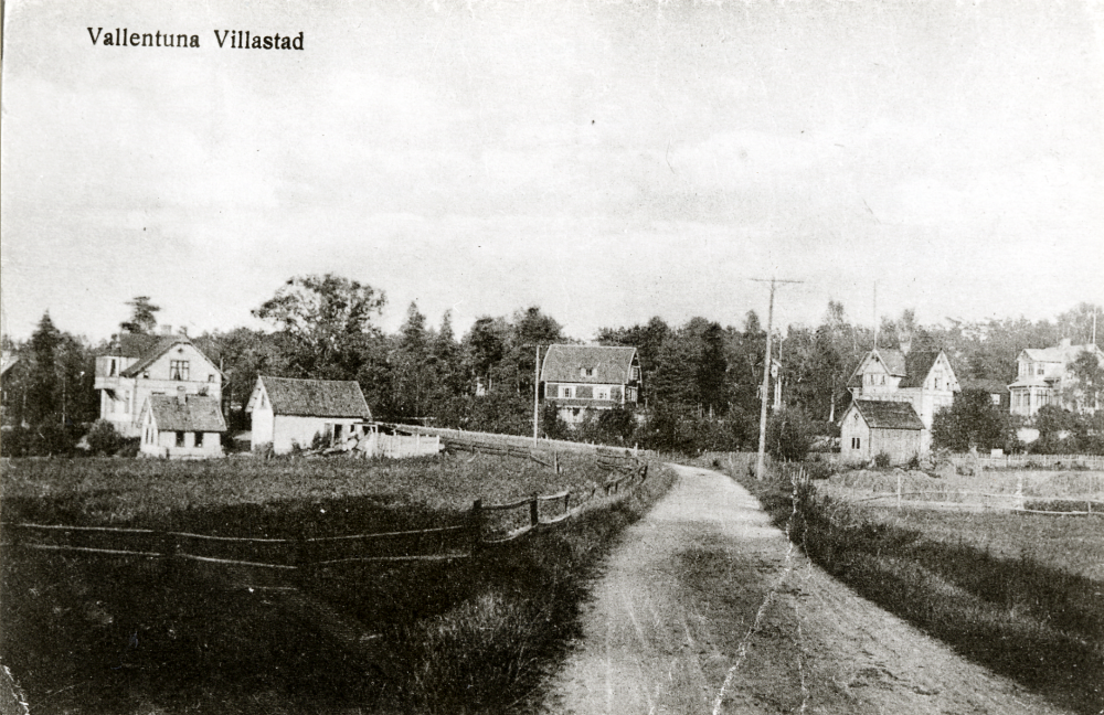 Vallentuna villastad   Stockholmsvägen  nuv  Karlbergsvägen  i bildens mitt. T v syns  Palmblads affär  och t h  Villa Svensborg  där senare författaren  Jan Fridegård  bodde. Kopia av vykort.