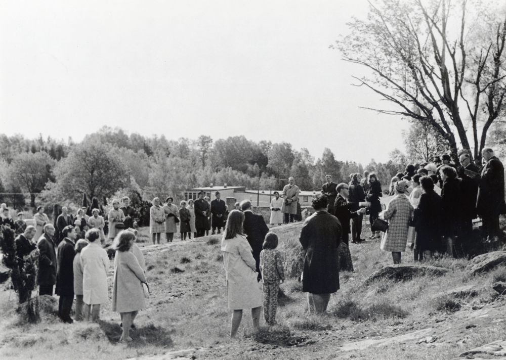 Gökotta i Ormsta hage med sång av ?? under ledning av ???.  I bakgrunden syns småskolan vid Ormstaskolan