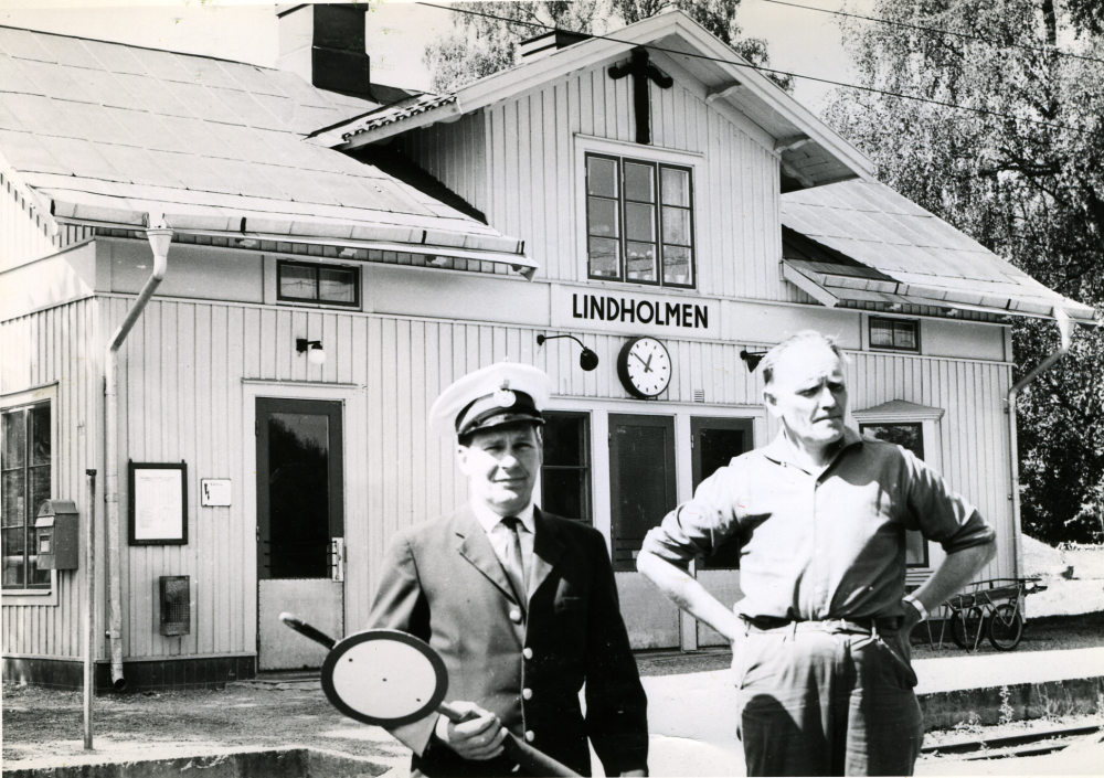 Utanför Lindholmens järnvägsstation står lantbrevbärare Gerhard Holm och stins Eje Bylund. Gerhard var född 1918 och yngst av fyra bröder.