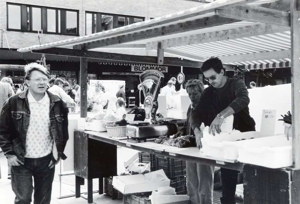 Bernt Klingberg från Grönsaksbutiken säljer frukt och grönsaker på Tuna torg.  Till hjälp har han svägerskan Birgitta Hofgren-Fransson (eller är det hustrun Gunilla??)