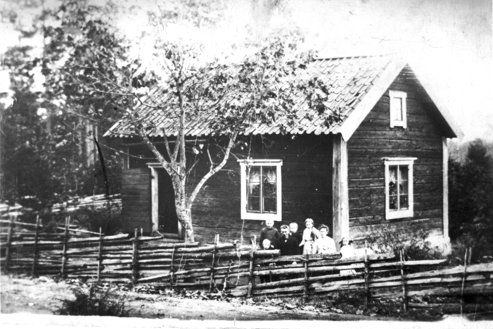 Skomakare Hjalmar Lundvall, född 1878 i Vada, med familj utanför sitt hus Norrbacka även kallat grindstugan på gränsen till Lunda eller skomakarns. Hjalmar flyttade till Norrbacka 1902 och gifte sig med Wilhelmina Lundin, född 1879 i Lunda.

Originalet finns hos Lunda Hembygdsförening.