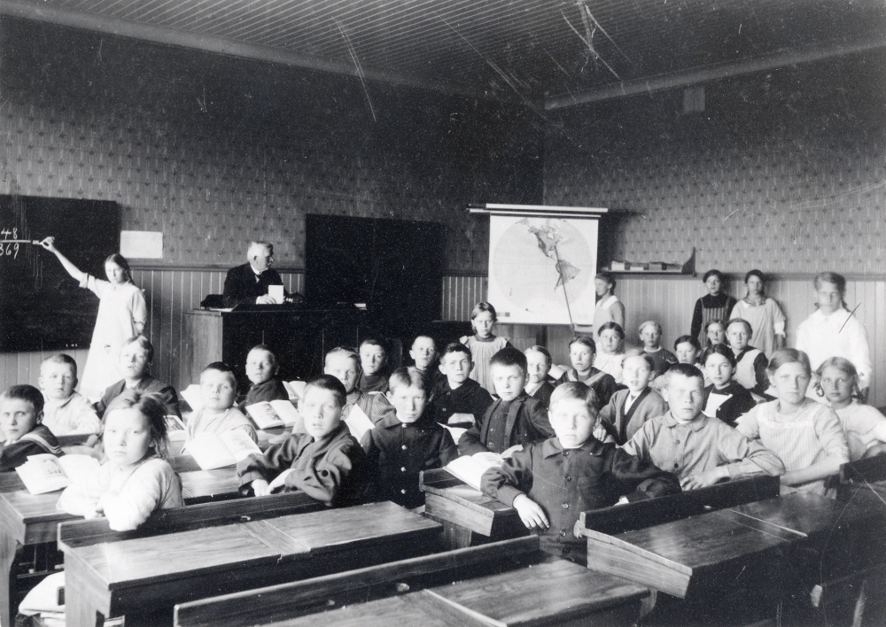 Läraren  Fritiof Sundell  tillsammans med skolbarnen inne i klassrummet i  Kårsta skola.  Skolan användes t o m vårterminen 1982