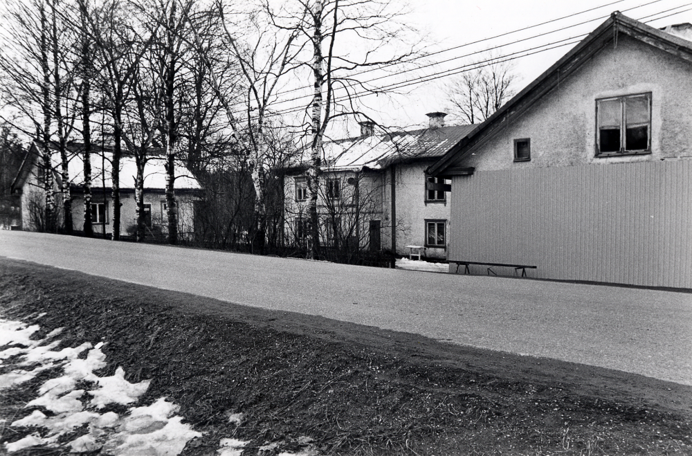 Åbyholms gård med huvudbyggnaden och de två flyglarna. Gården är i dåligt skick. Trafiken mot Lindholmen passerar nära den norra flygeln, väggen är förstärkt