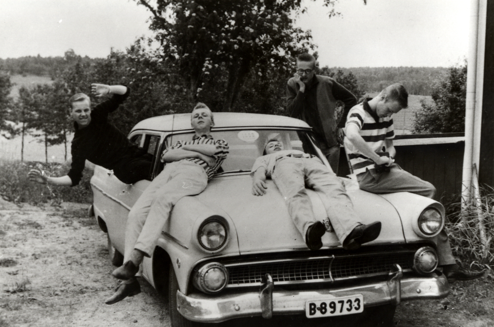 Unga "raggare" i Brottby.  Bilen är en Ford Customline av 50-talsmodell, köpt av Kjelle för 2 900 kr.  I och på bilen sitter fr v Willy med okänt efternamn, Nisse Jansson, Lasse Jansson, Kjell Andersson och Ove Söderblom