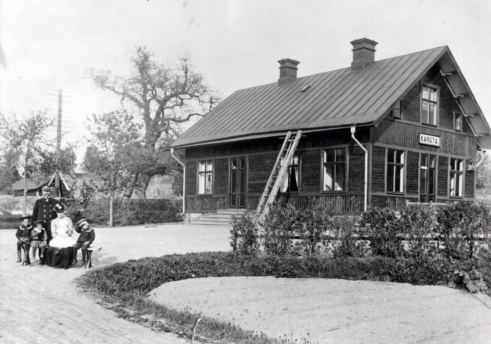 Stationsinspektör Gustavsson och hans hustru tillsammans med barnen Karl, Elsa, Erik (i moderns knä) och Herman utanför Kårsta järnvägsstation. I den stora eken till vänster om stationshuset finns en punschveranda