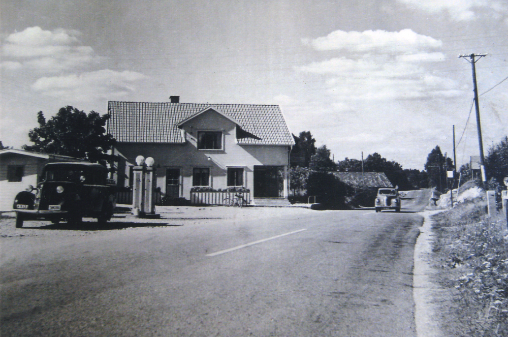 Bergsättra strax efter ombyggnaden 1947.  Här drev Seth Abel Axén  (1899-1986)café och bensinstation.  I verksamheten hade han hjälp av hustrun Ruth (1904-2003) samt systern Olga Axén (död 1951). Han började med en kiosk på 1930-talet.  Bensinmärket var Shell.  1947 byggdes fastigheten om.  Ev är den mörka bilen t v en Ford Eifel, den ljusa bilen en Hillman?  Förmodligen kopia av ett vykort utgivet av L Friberg, Stockholm