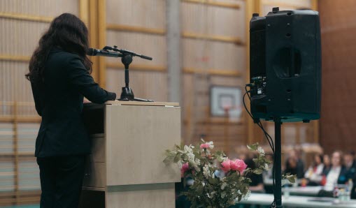 Elev håller tal från scenen framför andra elever som en del i uppmärksammandet av FN-dagen.