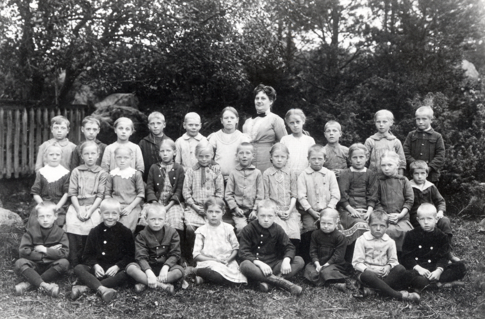 Lärarinna Anna Österberg senare gift Mattsson, tillsammans med skolbarnen i klasserna 1 till 3 i Torsholma skola. Nedersta raden fr v Gunnar Dahlberg, Harry Thorell, Christian Laurell, Ingeborg Lindblom, Göte Eriksson, Lisa Öhrling, Harry Mattsson och Henry Thorell. Rad 2 fr v: Elin Andersson, Maria Gustafsson, Vera Österberg, Elsa Andersson, Elsa Mattsson, Einar Jansson, Märta Johansson, Evert Johansson, Lilly Magnusson, Elsa Johansson och Albin Eriksson. Rad 3 fr v: Elof Ekvald, Elis Fröman, Astrid ?, Evert Israelsson, Gösta Mattsson, Constance ?, Betty Johansson, Sven Lindblom, Lisa Gustafsson och Gunnar Andersson