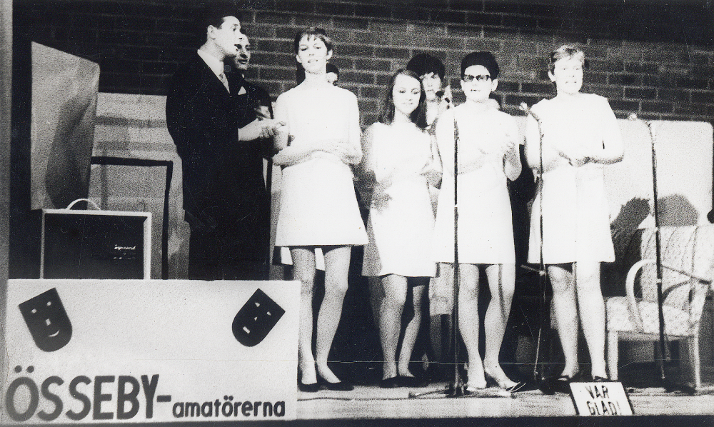 Össeby-amatörerna uppträder f f g i Karbyskolans gymnastisal  Valborgs-mässoafton 1967.  På scenen står fr v Åke Uddén, Nils-Ove Westerberg, Inger Eriksson Uddén, skymd Christina Lindersson, Ingela Wettervik, Anita Andersson Brisenmark, Evy Ländin Staff och Eva Alstermark Lind.  Bilden publicerad i Norrtelje Tidning, Per-Åke fick film av sin lärare för att stimulera fotograferandet och att skicka in bilder till tidningen