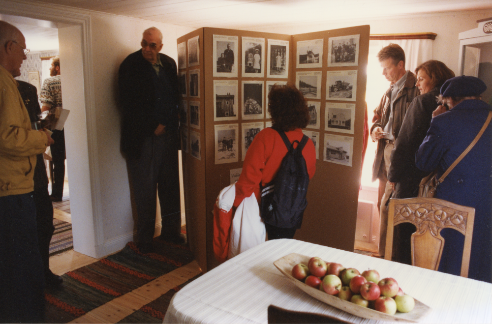Kvarnstugan i Brottby, Össeby hembygdsförenings hemvist. Interiör med besökare vid fotoutställningen från Vallentuna bildarkiv.
