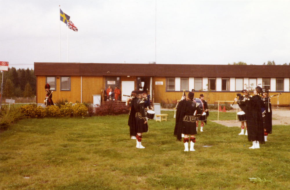 En musikkår från Storbritannien spelar utanför Gillingebanans kontorsbyggnad.