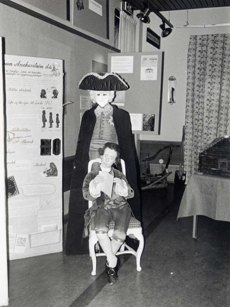 Eva Rahmqvist och Iréne Gustafson från kulturförvaltningen har under historieåret 1993 tillsammans med hembygdsföreningarna i Vallentuna producerat utställningen 1700-tal i Vallentuna.  Här sitter den unge Jacob Johan Anckarström d y, som senare skulle bli  Gustaf III:s baneman, vid de utställningsskärmar som redogör för Anckarströms liv på Lindö gård i Vallentuna.  Figuren är gjord av Eva Rahmqvist