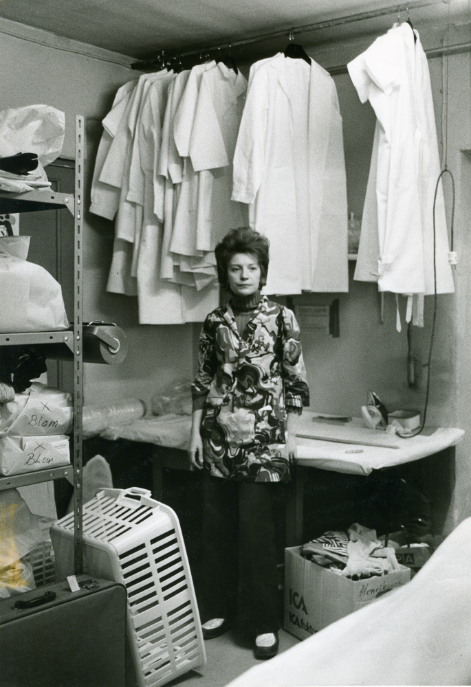 Interiör från Vallentunatvätten, tvätteriet vid Vallentunasjön. Personal vid strykbordet för vittvätt.

•Fotografiet ingår i bildserien ”Vardagsliv i Vallentuna kommun” av Rachael Gough-Azmier & Gunilla Blomé, Haga Studios HB.