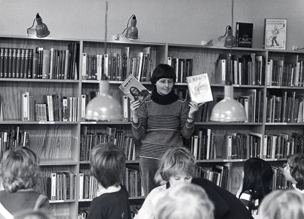 Ann Davidson  har besök i  Vallentuna bibliotek  i  barnavdelningen av skolans årskurs 3 och informerar om biblioteket. Biblioteket låg 1 trappa upp ovanför Konsum, nuvarande  Torghuset