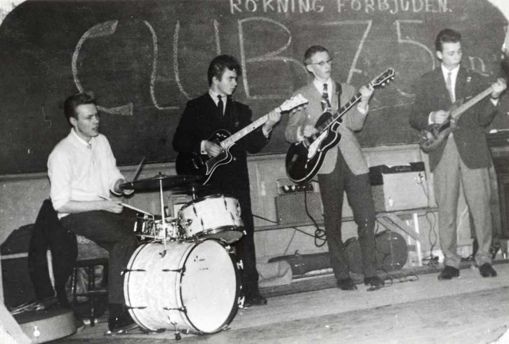 The Twanglers spelar i Stångberga skola, Össeby-Garn.  På scenen heter musikanterna fr v Ove Söderblom, Jan Andersson, "Gerre" Gert-Åge Frisk och Lasse Jansson.  Club 75 är skrivet på svarta tavlan