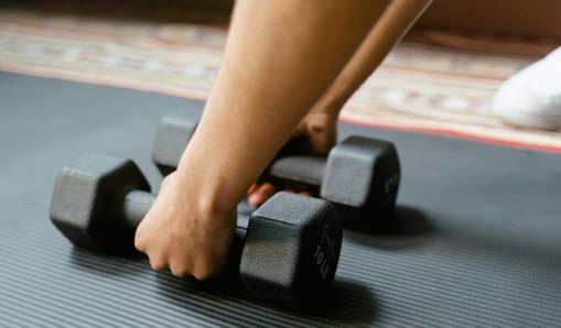 Händer som håller i hantlar