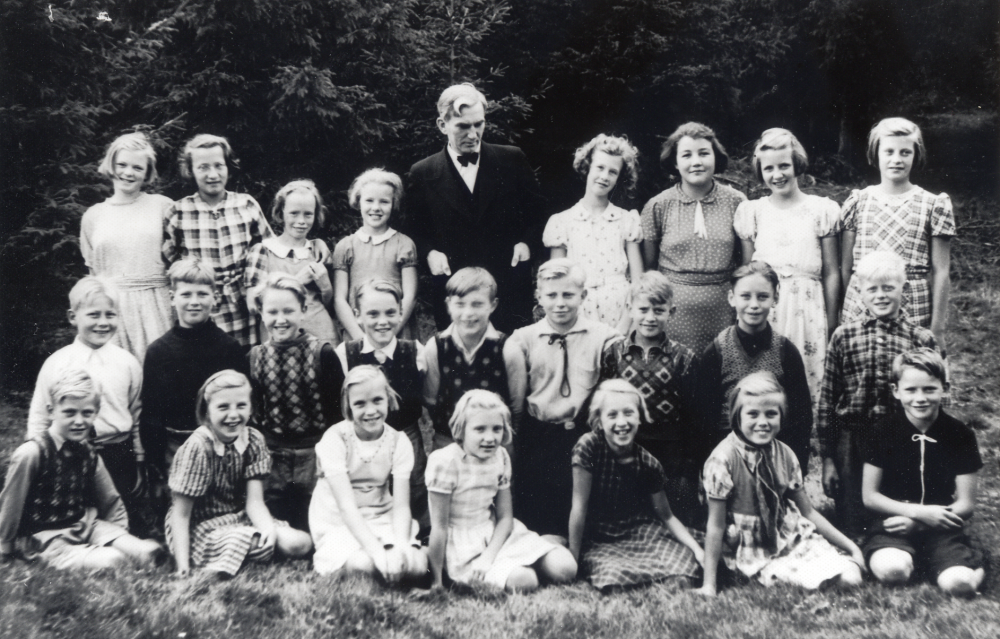Läraren Wilhelm Kant tillsammans med skolbarnen vid Markim-Orkesta folkskola.  Bakre raden fr v: Ing-Britt Jansson, Rose-Marie Beckman (Söderqvist), Anna-Greta Lundqvist (Thunholm), Gerd Forsberg (Wallin), Inga-Lill Eklöv, Britta Hedlund (Bergfors), Ulla-Britt Forsberg (Styffe) och Aina Andersson.  Knästående i rad 2 fr v: Allan Jansson, Åke Andersson, Folke Thunberg, Bert Lindström, Sture Lindqvist, Bertil Söderqvist, Nils-Åke Andersson (Springstedt), Karl-Erik Björkman och Karl-Erik Jansson.  Sittande i nedersta raden fr v: Curt Ehrman, Inga-Lisa Wallén, Rosa Åhlén, Ulla Andersson (Thunberg), Gulli Larsson (Öhman), Ulla Andersson och Arne Lundqvist