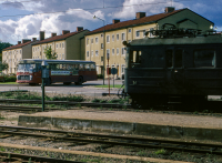 Vid Vallentuna station. En buss på Banvägen och ett tåg vid perrongen. I bakgrunden syns flerfamiljshusen på Centralvägen.
Bildserie: Vallentuna på 1960-talet.
