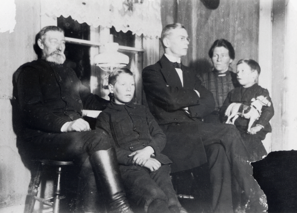 Carl Eric Norberg med hustrun Jenny och barnen Gotthold, Georg och Alexis.  Familjen bodde i Nannyberg, Rävsta i Angarn.  Fotograf är förmodligen Georg, foto ca 1912-1914.  Stugan var från början garvarstuga i Brottby vid ån och flyttades tilll sin nuvarande plats 1890.  Carl Erik Norberg var fjärdingman