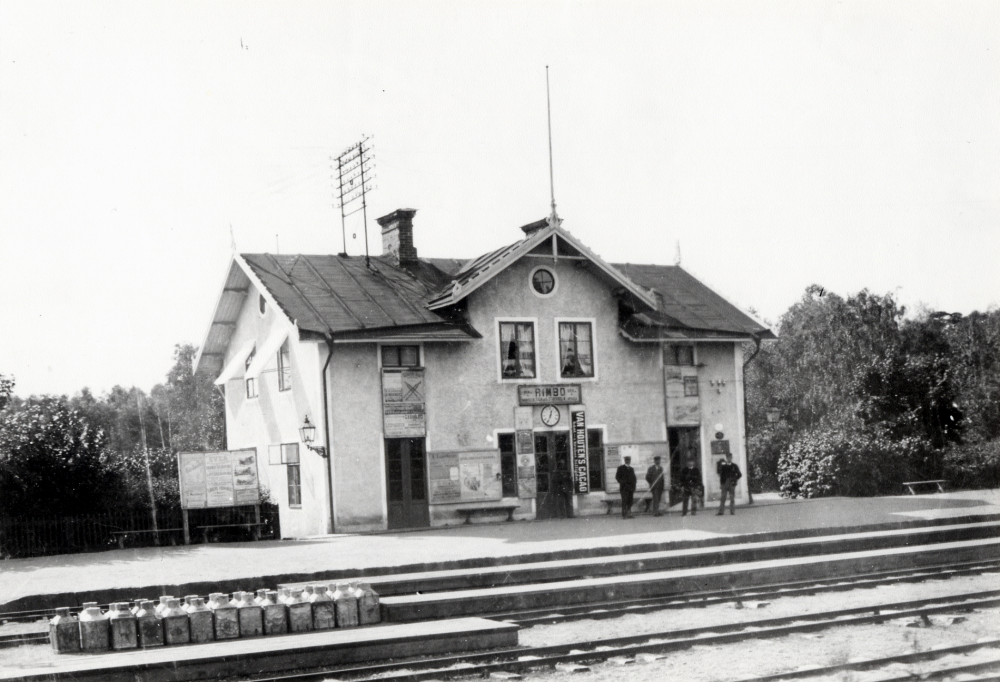 Rimbo järnvägsstation. På en träperrong står många mjölkflaskor. Mycket mjölk fraktades med Roslagsbanan till Stockholm