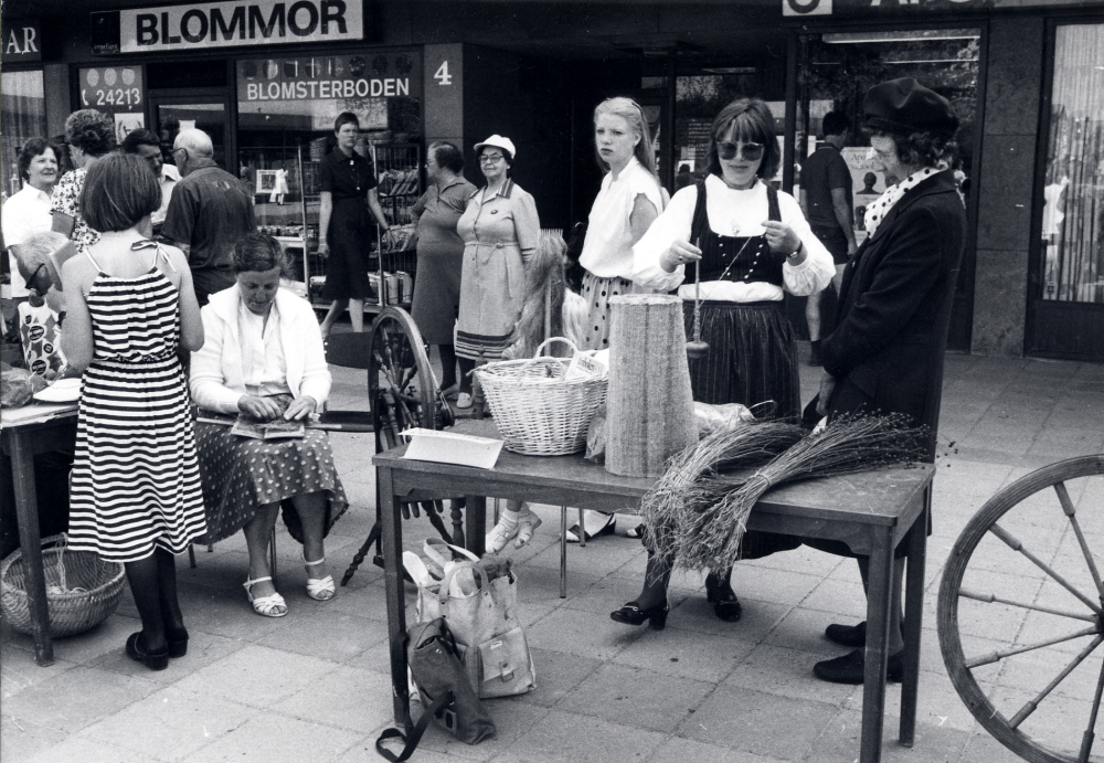 Vallentuna folkdansförening visar olika aktiviteter med tema Musik, slöjd och dans på Tuna torg. Här kardar Eva Kristiansson ull t v och okänd spinner lintråd med slända