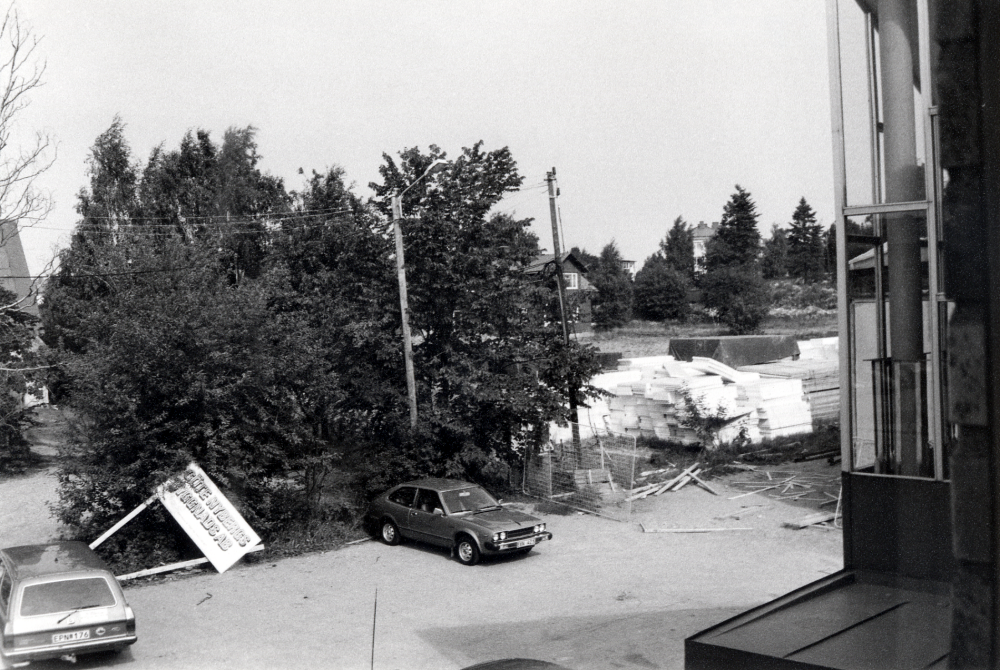 Utsikt från barnavdelning i Vallentuna bibliotek på Allévägen mot nordväst, där det nya centrumhuset Tärningen skall byggas.  T v skymtar taket på affären Kära Barn, i bildens mitt den norra syskonvillan samt norr därom ett av bostadshusen på Mörbyvägen