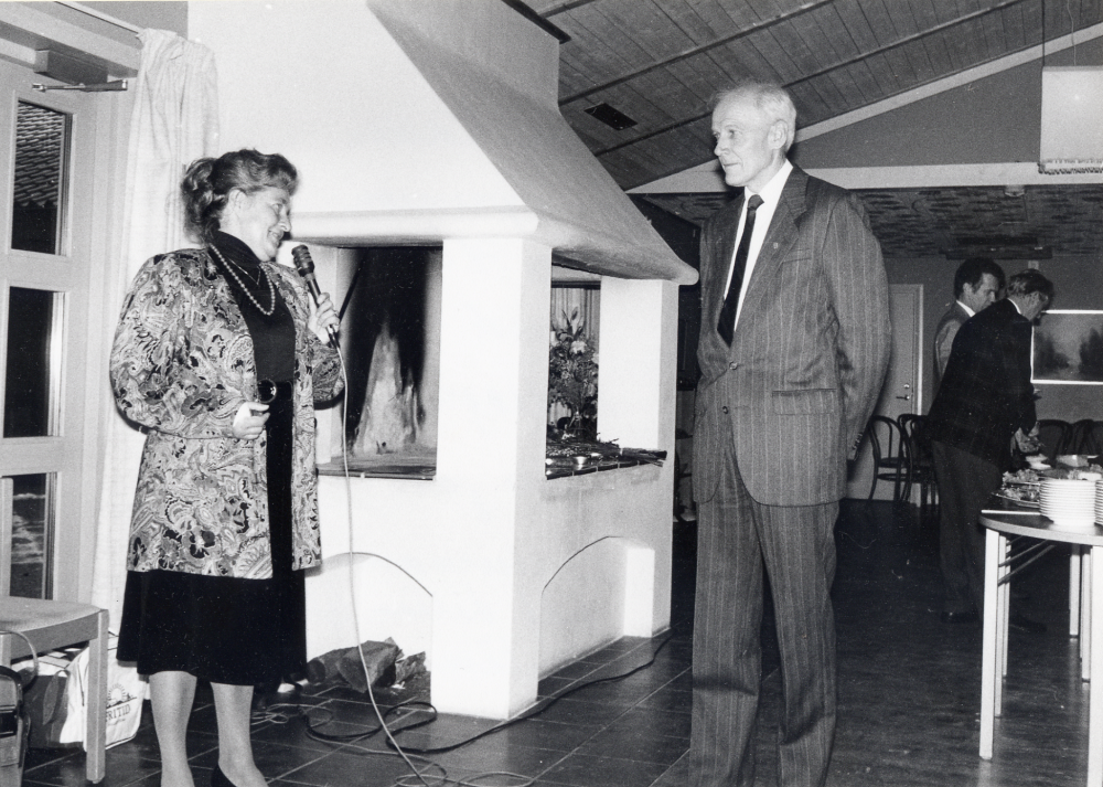 Kanslichef Gunnar Käller går i pension efter 38 års tjänst i Vallentuna kommun.  Kommunen anordnar avskedsfest med mottagning i Mathiasgården.  Här talar kulturnämndens ordförande Lilian Glav till Gunnar Käller. I bakgrunden vid det gående bordet står t v Folke Berglund och t h K G Jonsson