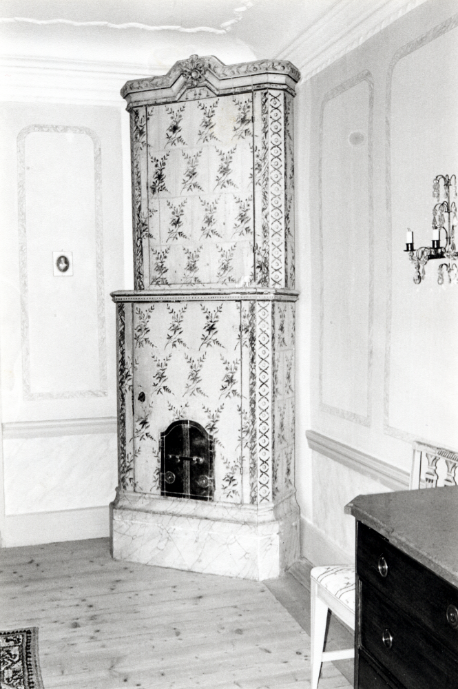 Skåp tillverkat som en kakelugn med mässingsluckor men med skåpdörr och nyckel finns på Lindö gård i Vallentuna.

Jämför bild 50 04 00: 153 – en riktig kakelugn på andra sidan dörren