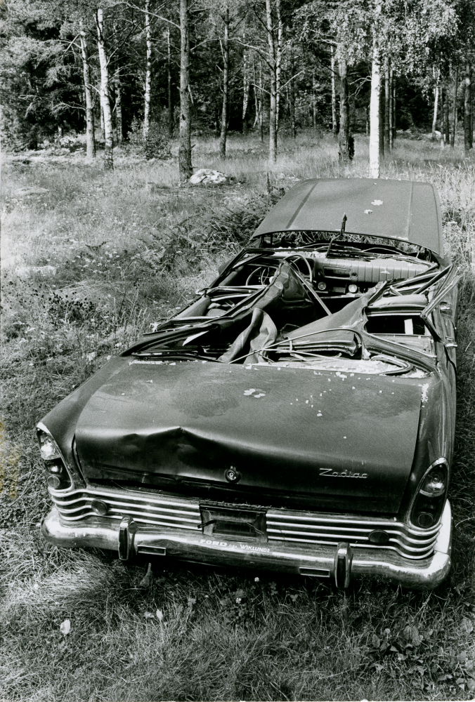 Ett bilvrak av märket Ford Zodiac har lämnats vid Lingsbergsvägen.
•Fotografiet ingår i bildserien ”Vardagsliv i Vallentuna kommun” av Rachael Gough-Azmier & Gunilla Blomé, Haga Studios HB.