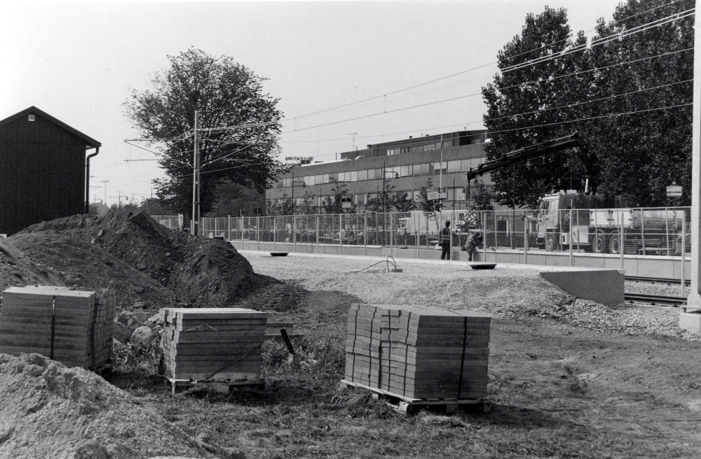 Vallentuna centrum vid ombyggnaden av Roslagsbanan vid järnvägsstationen sommaren 2002.  Trafiken är avstängd hela sommaren  till alla resandes förtret.  Stationområdet görs om med enbart två spår och två övergångar vid stationsområdets södra del.  Samtidigt flyttas stoppställe för tågen norrut.  I bakgrunden syns Tunahuset.  T v syns ett nybyggt  teknikhus med bl a stationens ställverk