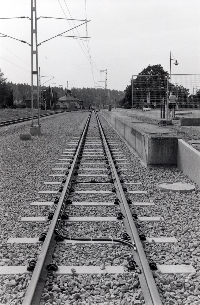 Vallentuna centrum vid ombyggnaden av Roslagsbanan vid järnvägsstationen sommaren 2002.  Trafiken är avstängd hela sommaren  till alla resandes förtret.  Stationområdet görs om med enbart två spår och två övergångar vid stationsområdets södra del.  Samtidigt flyttas stoppställe för tågen norrut.  Vy söderut mot Bällsta med nylagda räler och västra perrongen. I bakgrunden syns Ralles diner