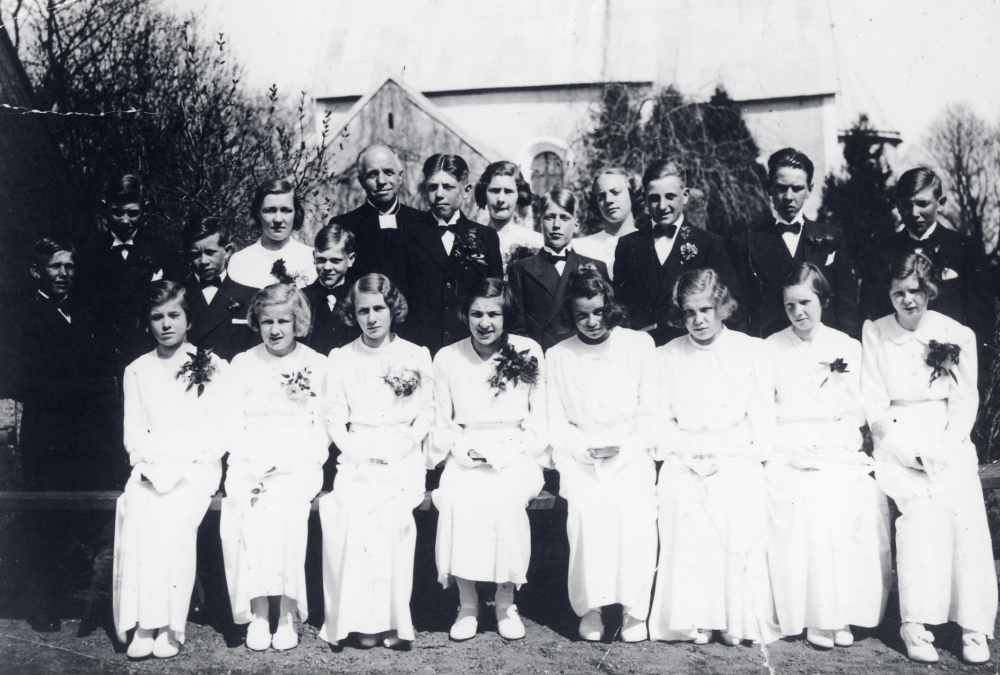 Konfirmation  i  Markims kyrka  Kyrkoherde  Johannes Uddin  bland sina  konfirmander  De sittande flickorna har alla utom en lång vit klänning