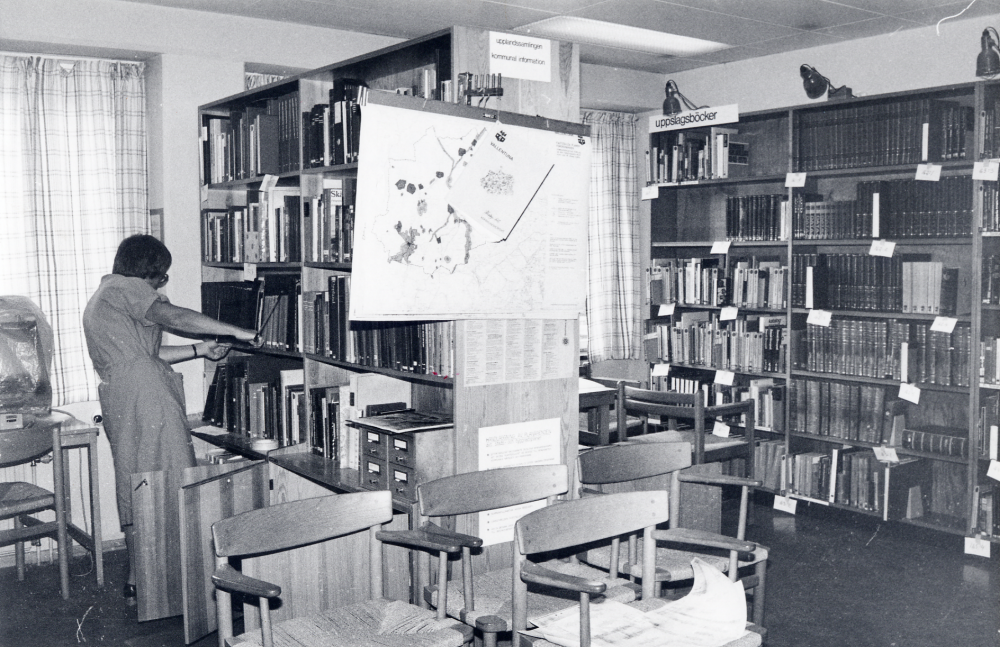 Vallentuna bibliotek på Allévägen.  Flyttningen till Tärningen skall påbörjas.  Fotografiet taget just innan de första flyttgubbarna kommmer.  Lena Wallén tittar i Upplandssamlingen innan allt skall packas ner
