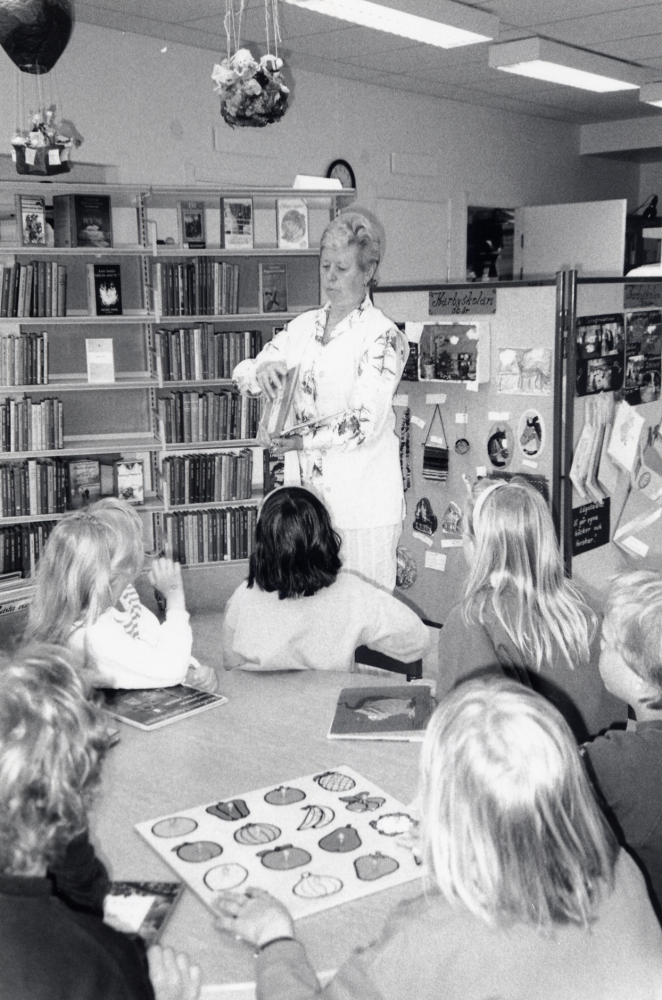 En sexårsgrupp på besök i Karby bibliotek.  Gunvor Svensson berättar hur man lånar böcker och barnen får egna lånekort