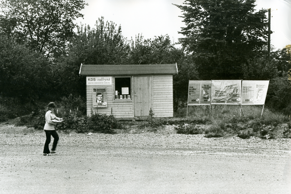 Kristdemokraternas valbyrå och valaffischer på Banvägen.
•Fotografiet ingår i bildserien ”Vardagsliv i Vallentuna kommun” av Rachael Gough-Azmier & Gunilla Blomé, Haga Studios HB.
