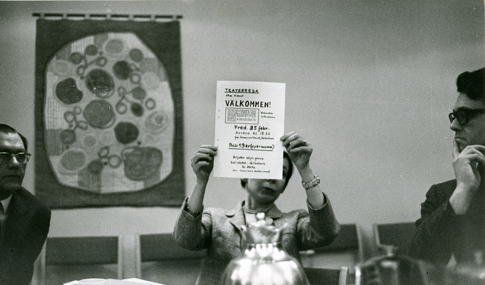 Kulturnämndens kontaktträff på Väsbygården. Från vänster, kulturnämndens ordföranden Carl-Erik Wikström, sekreterare och bibliotekschef Elsa Oskarsson och ledamoten Leif Magnusson. Elsa Oskarsson håller upp ett anslag, "Teterrresa Allan Edwall Välkommen!..."

•Fotografiet ingår i bildserien ”Vardagsliv i Vallentuna kommun” av Rachael Gough-Azmier & Gunilla Blomé, Haga Studios HB.