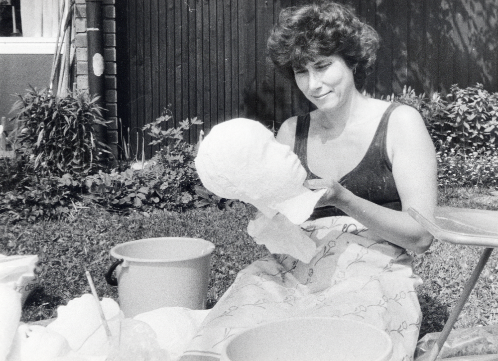 Eva Rahmqvist ,  född 1943,  arbetar med en ansiktsmask av gips till utställningen  Barn i slott och koja  på Läckö slott.   Maskerna är avgjutningar med gipsbindor från ansikten.  Familj, grannar och goda vänner har fått stå modell till flertalet figurscener i naturlig storlek till utställningar runt om i Sverige.  Evas arbeten finns att se bl a på Vasamuseet.   På Vallentuna bibliotek är hennes utställningar i Vallentunasalen och i Kulturfönstret välkända.  Här fotograferad i trädgården på Bällstavägen i Vallentuna.