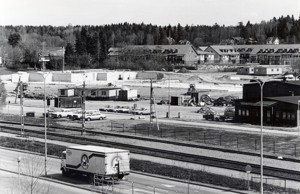 Vallentuna sjukhem och distriktläkarmottagning skall få nya lokaler på andra sidan järnvägen vid hörnet Åby gata och Industrivägen. I förgrunden syns på Banvägen en varubil från Polarkakan och Roslagsbanans spår samt t h Vallentuna värmeverk. I bakgrunden bostadsomsrådet Åby gärde